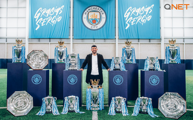 Sergio Aguero posing with all the trophies won at Manchester City