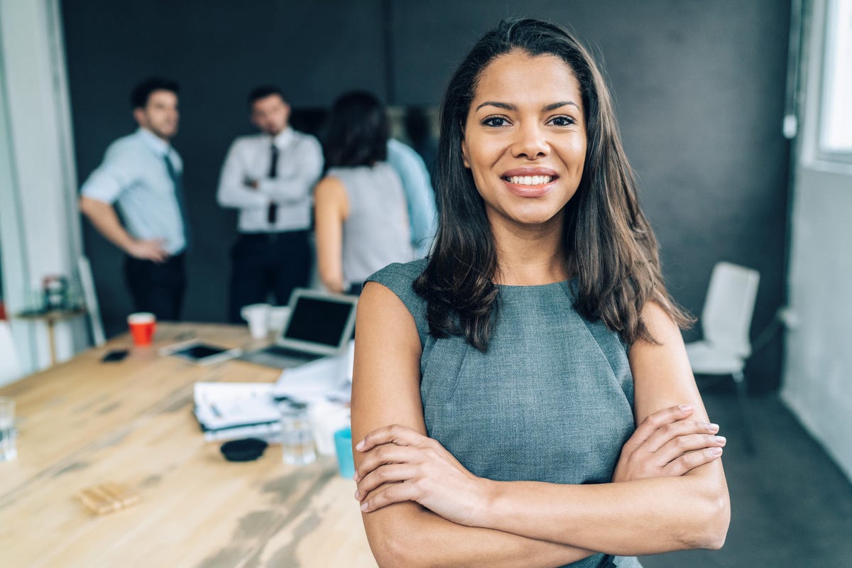 building confidence in sales - a woman standing with her arms crossed in her office 