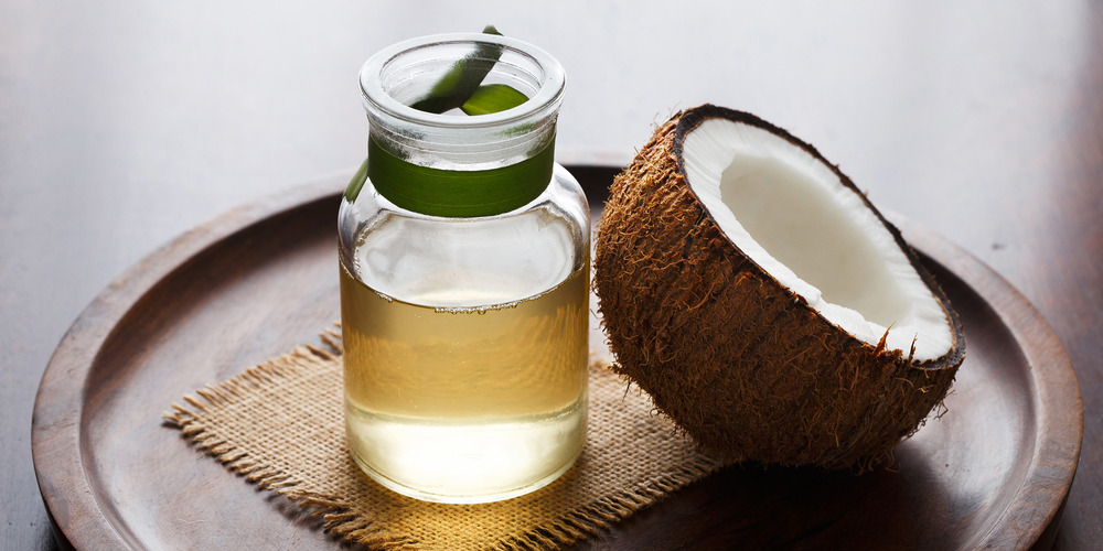 a jar of coconut oil next to a coconut 