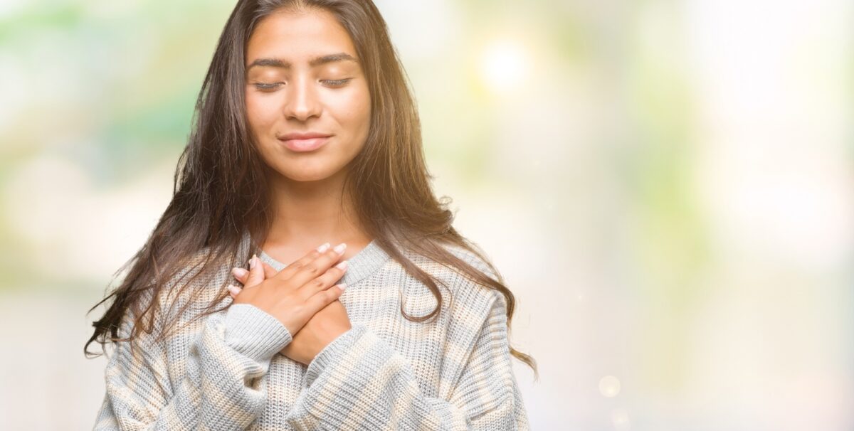 a girl holding her hands together over her heart - why immune system is essential for health 