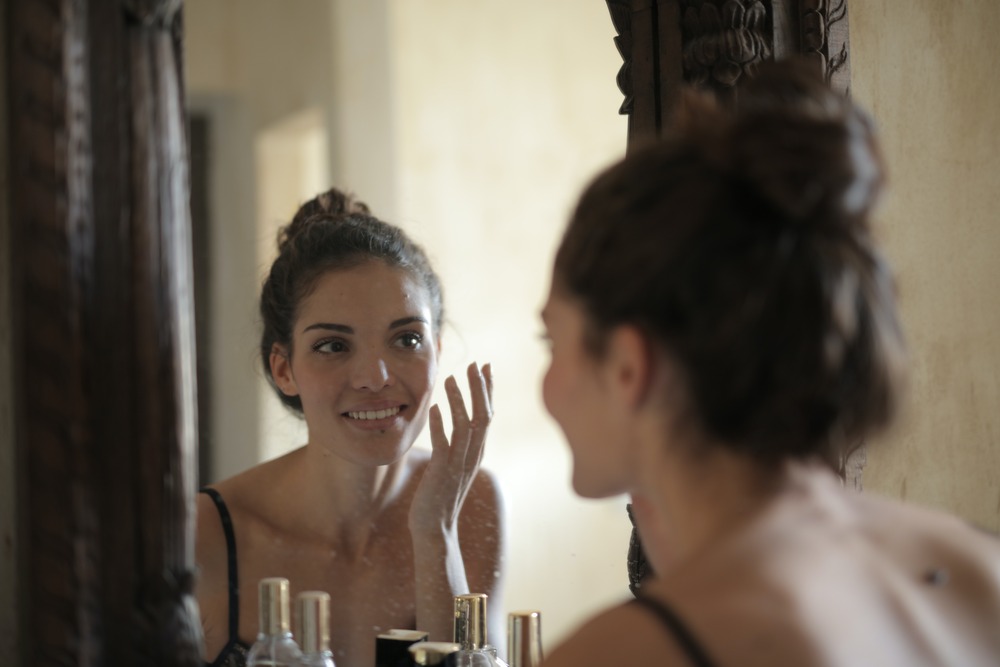 a girl looking at herself in the mirror