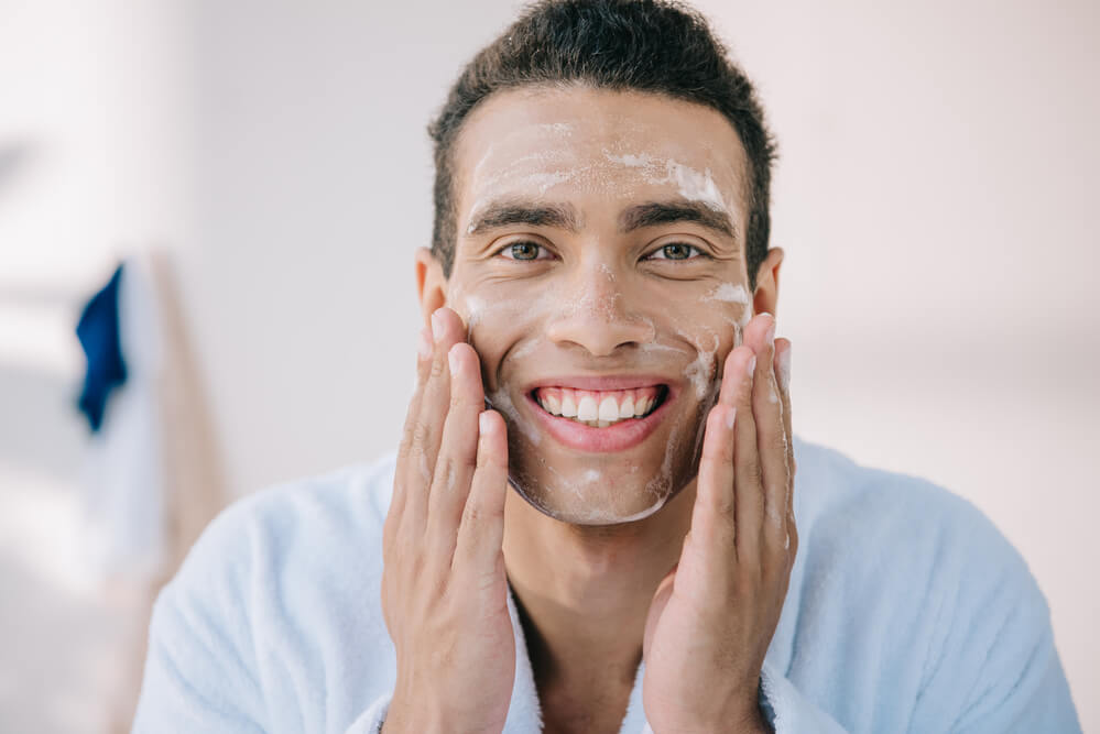 a man moisturizing his face - winter skin care products
