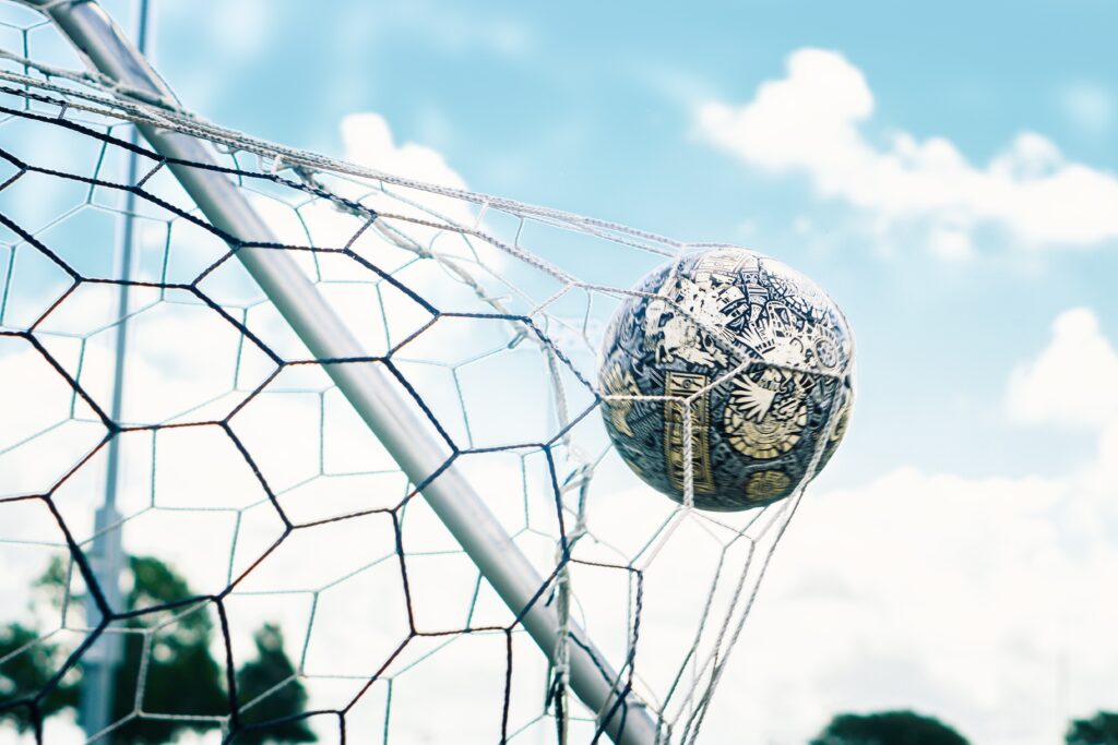 A football inside the net. Pep Guardiola 5 strategies for success.